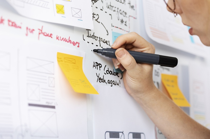 web-designer-feminina-com-papeis-e-notas-no-escritorio-7136514.jpg